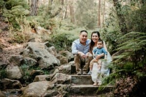 Maternity session - a family sit cuddling together on sandstone steps