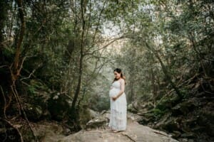 Maternity Session - Pregnant mamma stands on a rock in the bush