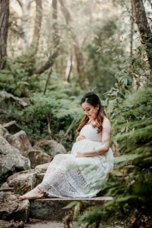Maternity Session - A pregnant mother holds her belly sitting on sandstone steps