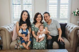 Newborn session - a family sit with their new baby in their lap