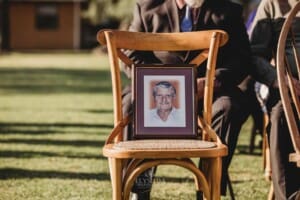 Gledswood Wedding - portrait of the brides grandfather sits on a chair