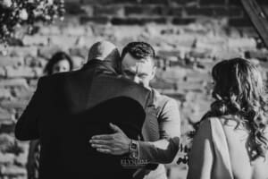 Gledswood Wedding - groom hugs the brides father