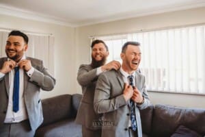 Gledswood Wedding - grooms man adjusts the grooms suit