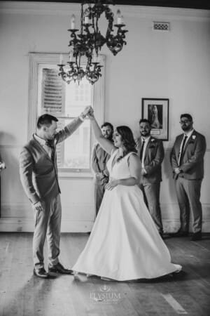 Gledswood Wedding - groom twirls the bride as the practice dancing