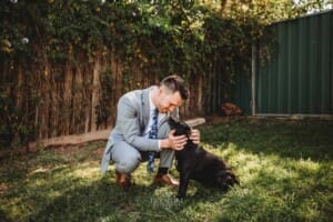 Gledswood Wedding - groom pats his dog before the ceremony