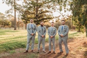 Gledswood Wedding - groom stands with his groomsmen at sunset