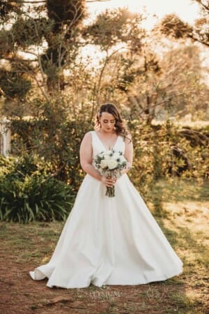 Gledswood Wedding - bride poses at sunset in the venue grounds
