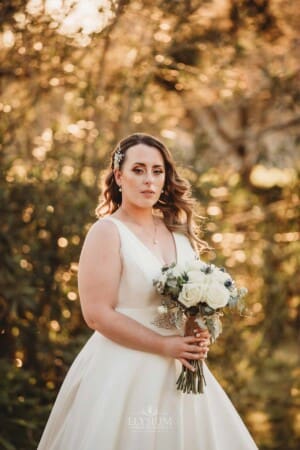 Gledswood Wedding - bride poses at sunset in the venue grounds