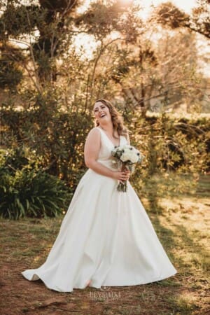 Gledswood Wedding - bride poses at sunset in the venue grounds