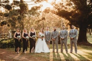 Gledswood Wedding - bridal party stand in the venue grounds at sunset