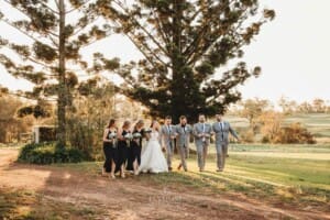 Gledswood Wedding - bridal party walk across the venue grounds at sunset