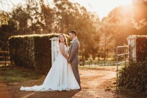 Gledswood Wedding - bride and groom stand in the venue driveway at sunset