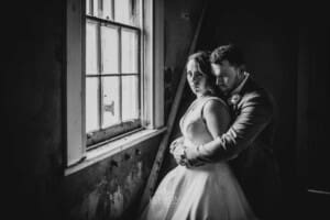 Gledswood wedding - bride and groom stand next to a window in the homestead venue