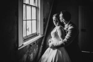 Gledswood wedding - bride and groom stand next to a window in the homestead venue