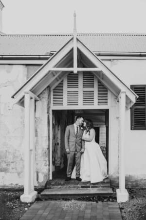 Gledswood wedding - bride and groom share a kiss in a venue doorway