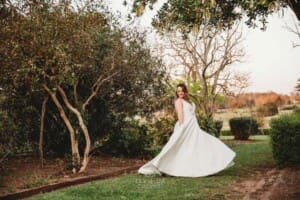 Gledswood wedding - bride twirls her gown in the venue gardens