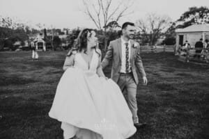 Gledswood wedding - bride and groom walk across the venue grounds towards the reception