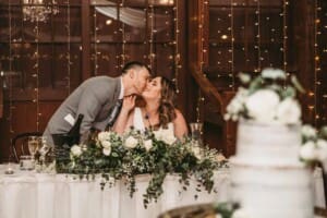 Gledswood wedding - groom kisses his bride on the cheek at the reception