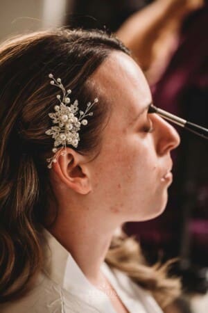 Gledswood Wedding - make-up artist applies eyeshadow to the bride