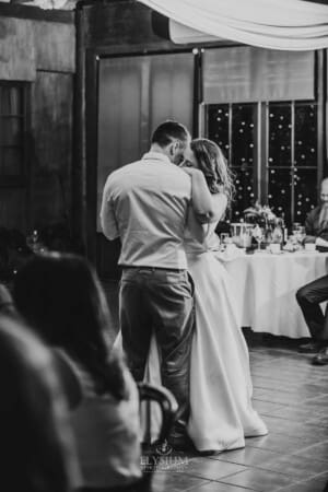 Gledswood wedding - the bride cuddles into the groom as they dance at the reception