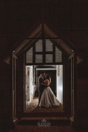 Gledswood wedding - newlyweds cuddle in a doorway of the homestead