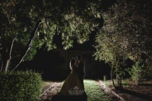 Gledswood wedding - newly married couple hug under trees at night