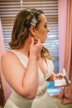 Gledswood Wedding - bride puts on earrings before the ceremony