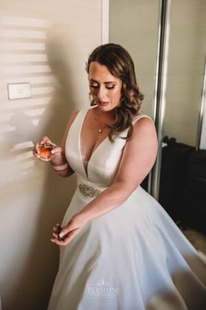 Gledswood Wedding - bride applies perfume