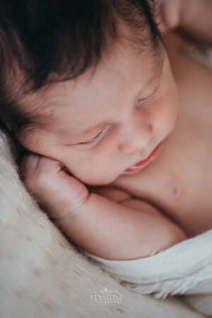 Newborn session - newborn baby sleeping, little hand resting on his cheek