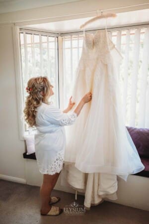 Gledswood Wedding Photo - Bride inspecting her wedding gown