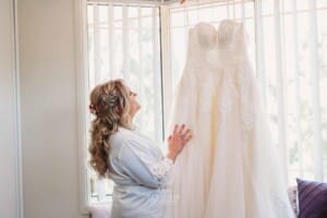 Gledswood Wedding Photo - Bride gently touches her wedding gown