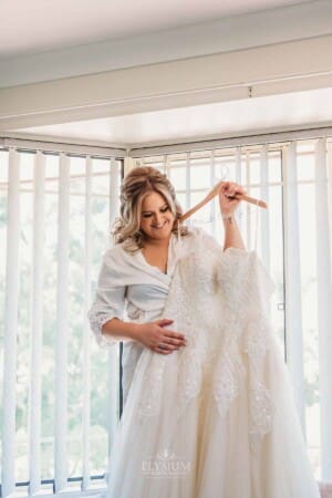 Gledswood Wedding Photo - Bride holds her wedding gown