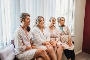 Gledswood Wedding Photo - Bride sits with her bridesmaids