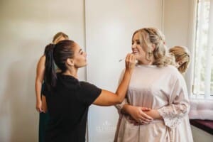 Gledswood Wedding Photo - makeup artist applies lipstick to the bride