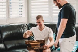 Gledswood Wedding Photo - Groomsman opens a gift from the groom