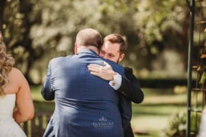 Gledswood Wedding Photo - groom hugs the brides father