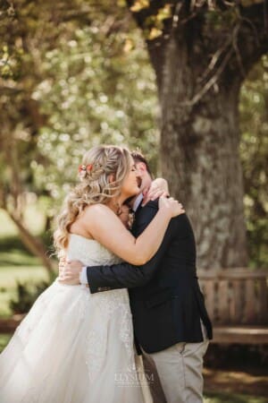 Gledswood Wedding Photo - bride and groom hug during the ceremony