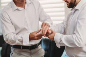 Gledswood Wedding Photo - Groomsman helps the groom with his cufflinks