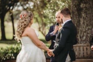 Gledswood Wedding Photo - bride and groom listen to a verse during the ceremony