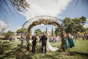 Gledswood Wedding Photo - bride and groom stand under the arch during the ceremony