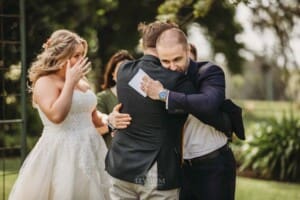 Gledswood Wedding Photo - groom hugs the brides brother during the ceremony