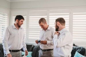 Gledswood Wedding Photo - Groomsman helps the groom with his cufflinks