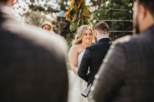 Gledswood Wedding Photo - bride and groom stand under the arch during the ceremony