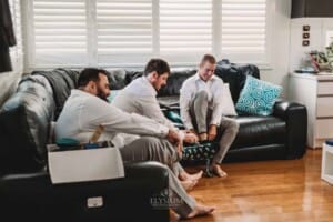 Gledswood Wedding Photo - Groomsmen sit to put on their shoes
