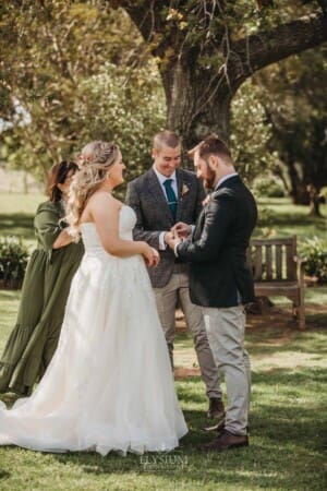 Gledswood Wedding Photo - bride and groom exchange wedding rings during the ceremony