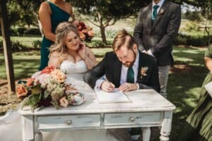 Gledswood Wedding Photo - bride and groom sign the marriage certificate