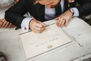 Gledswood Wedding Photo - bride and groom sign the marriage certificate
