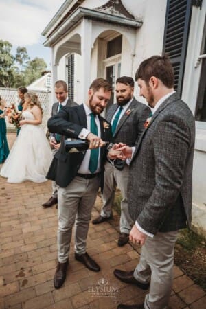 Gledswood Wedding Photo - the groom pours champagne glasses
