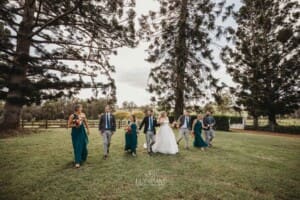 Gledswood Wedding Photo - the bridal party walk across the homestead lawn