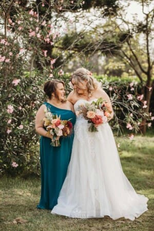 Gledswood Wedding Photo - the bride stands laughing with her bridesmaid